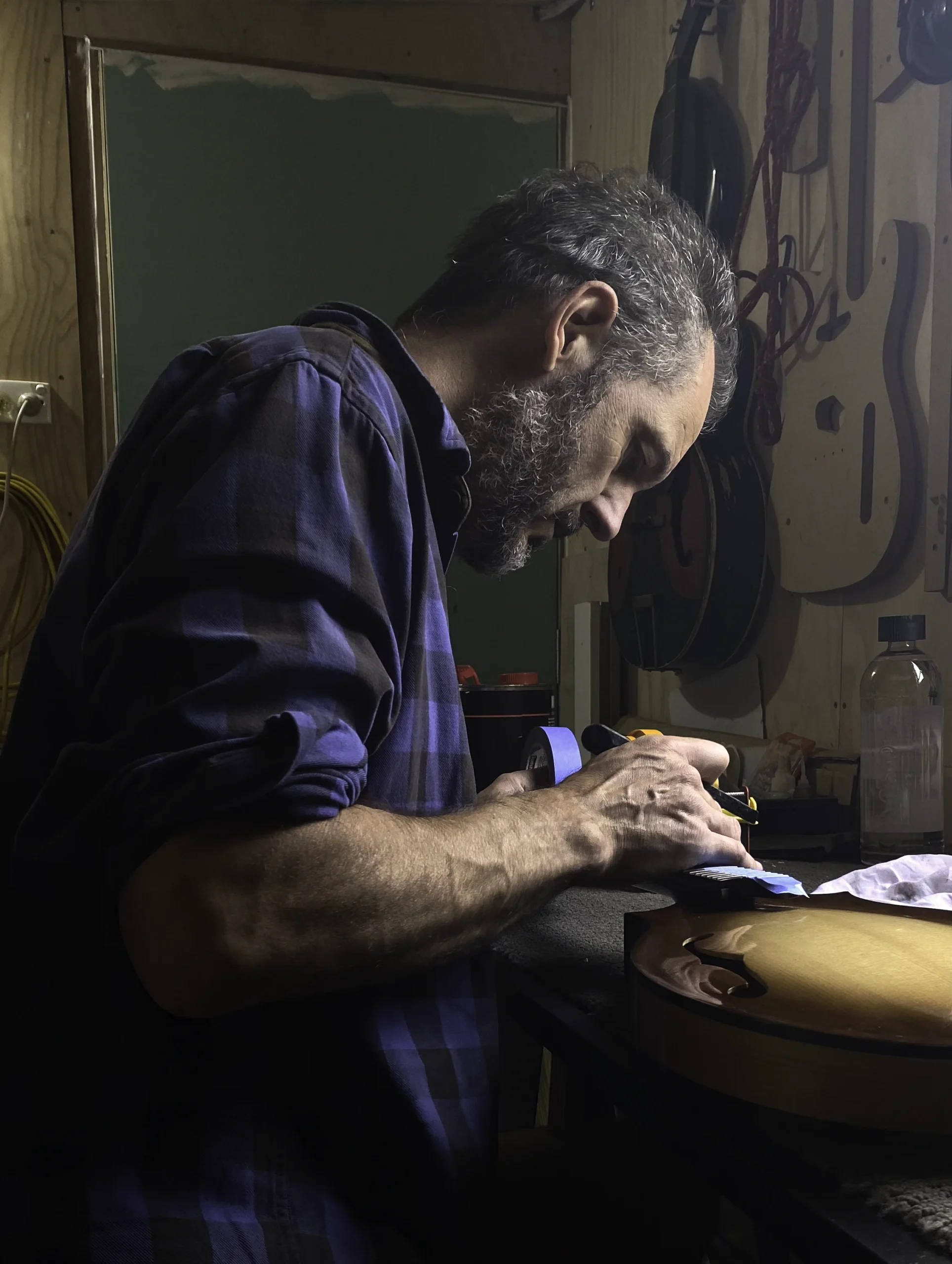 Lachlan Maclennan Luthier and maker in his studio working on a custom mandolin.